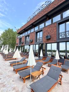 a row of lounge chairs with umbrellas in front of a building at No Stress in Borča
