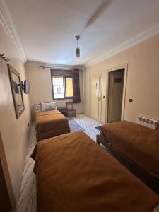 a hotel room with three beds in a room at Hotel Aswan in Oujda