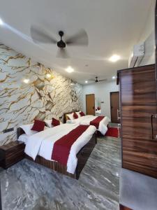a bedroom with two beds and a stone wall at Hotel Pushkar Pulse in Pushkar