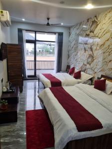 a bedroom with two beds and a stone wall at Hotel Pushkar Pulse in Pushkar +4 photos