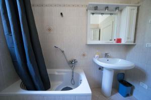 a bathroom with a tub and a sink and a shower curtain at Casa Natalina in Montecatini Terme +36 photos