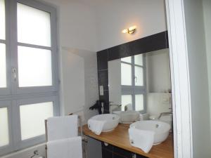 a bathroom with two sinks and two mirrors at A la Fleur de Lys in Langeais +65 photos