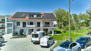 a house with a solar roof and cars parked in a parking lot at Starnberger See Apartments in Starnberg