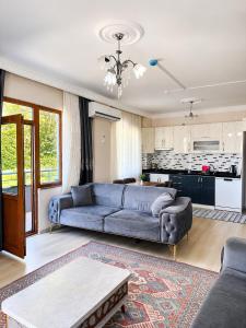 a living room with a blue couch and a kitchen at Rize Akarsu Apart in Rize