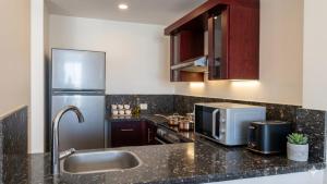 a kitchen with a sink and a stainless steel refrigerator at شاليه 2 غرفه in Marsa Alam +7 photos