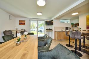a dining room and living room with a wooden table and chairs at Starnberger See Apartments in Starnberg