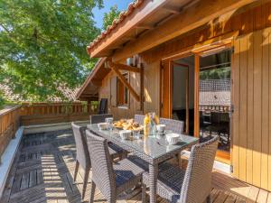 a patio with a table and chairs on a deck at Vacancéole - Les Rives du Lac in Lacanau