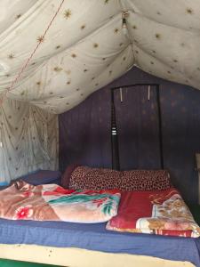 a bed in a tent with a canopy at HIMALAYAN ESCAPE CAMP chopta in Chopta