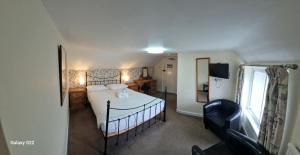 a bedroom with a bed and a chair in it at Trehellas House Hotel & Courthouse restaurant in Bodmin