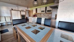 a kitchen with a wooden table with chairs and a dining room at Ferienwohnung Kohler - Königsfeld in Königsfeld