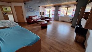 a living room with a bed and a couch at Ferienwohnung Kohler - Königsfeld in Königsfeld