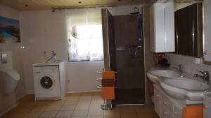 a bathroom with a sink and a washing machine at Ferienwohnung Kohler - Königsfeld in Königsfeld +13 photos