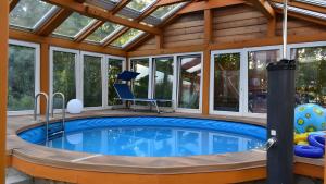 an indoor pool in a house with a glass ceiling at Ferienwohnung Kohler - Königsfeld in Königsfeld