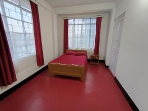 a small room with a bed and two windows at LeeZaiah in Shillong