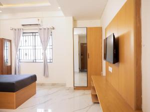a room with a bed and a tv and a window at Z Express Aradhana in Bangalore