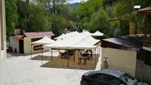 a group of tables and white umbrellas in a courtyard at Dilichella Resort in Dilijan