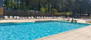 a swimming pool with two people walking in the water at la dune blanche in Camiers