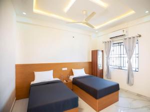 a bedroom with two beds and a ceiling fan at Z Express Aradhana in Bangalore