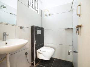 a bathroom with a white toilet and a sink at Z Express Aradhana in Bangalore +14 photos
