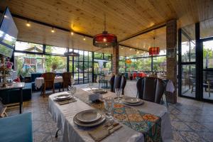 a dining room with tables and chairs and windows at Hedi in Mtskheta