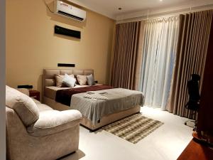 a bedroom with a bed and a chair and a couch at Isle Weligama in Weligama