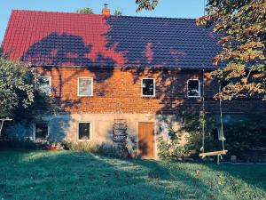 a large brick house with a red roof at Na końcu dróżki in Radoniów