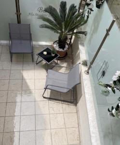 a patio with a table and chairs and a plant at B&B Alla Stazione in Palermo