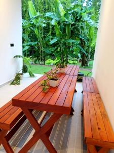 a wooden table with potted plants on a balcony at Isle Weligama in Weligama