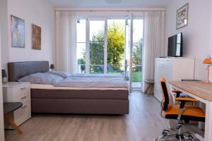 a bedroom with a bed and a desk and a window at Terrasse im Ammergau - Bad Kohlgrub in Bad Kohlgrub