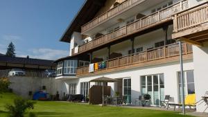 an apartment building with a balcony and a yard at Terrasse im Ammergau - Bad Kohlgrub in Bad Kohlgrub