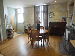 a dining room with a table and a piano at A la Fleur de Lys in Langeais