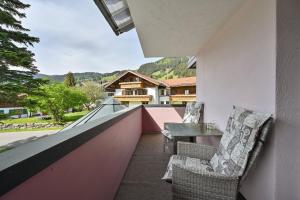 a balcony with chairs and a table on a building at Vintage Hotel Charivari- Sommer Hörnerbahnen kostenlos mit Restaurant in Bolsterlang