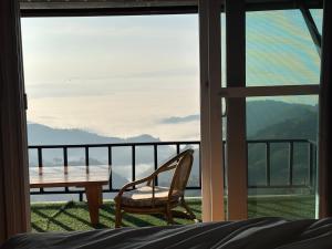 a room with a table and a chair on a balcony at มาภูโฮมสเตย์ in Chiang Rai