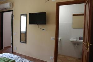 a bedroom with a tv on the wall and a sink at Agriturismo I TRE TIGLI in Rignano Flaminio