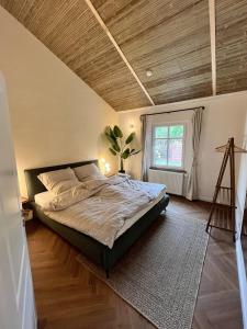 a bedroom with a large bed with a wooden ceiling at Wooden Silence - Wo Ruhe zuhause ist in Soltau