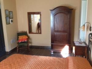a bedroom with a wooden cabinet and a mirror at Podere Caselina b&b in Camugnano
