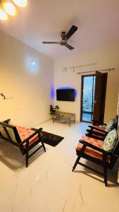 a living room with chairs and a flat screen tv at Boutique Bungalow 458 in Secunderabad