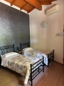 zwei Betten in einem Zimmer mit einer Wand in der Unterkunft Samarcanda Hotel & Parking di Parmigiani Silvia in Civitavecchia