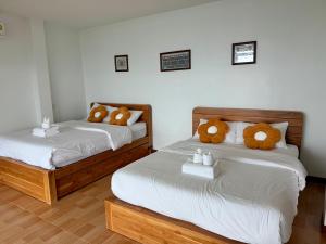 two beds with teddy bears on them in a room at มาภูโฮมสเตย์ in Chiang Rai