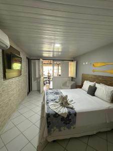 a bedroom with a large bed and a living room at Pousada Maraoka in Porto De Galinhas +87 photos