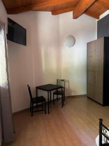 ein Esszimmer mit Tisch, Stühlen und Fernseher in der Unterkunft Samarcanda Hotel & Parking di Parmigiani Silvia in Civitavecchia