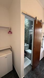 a bathroom with a toilet and a sink and a door at Pousada Bahan Suites privativas - ideal para Casais in Ubatuba +42 photos