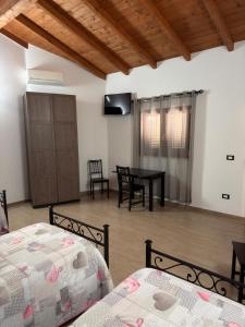 ein Schlafzimmer mit zwei Betten, einem Tisch und Stühlen in der Unterkunft Samarcanda Hotel & Parking di Parmigiani Silvia in Civitavecchia + 2 Fotos