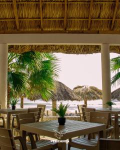 a table and chairs with a view of the beach at PELÍCANOS Hotel & Beach Club in El Zapote +12 photos