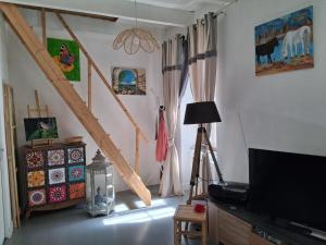 a living room with a tv and a tripod in a room at Les volets bleus in Prémian