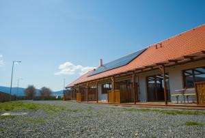 a building with a red roof with a picnic table at 4 Fa Apartmanok in Miercurea-Ciuc