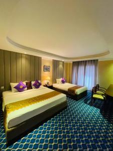 a hotel room with two beds in a room at The Green Shadow Business Hotel in Chittagong