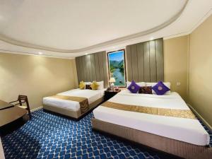 a hotel room with two beds and a window at The Green Shadow Business Hotel in Chittagong +12 photos