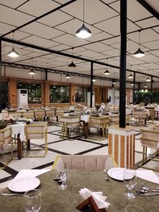 an empty restaurant with tables and chairs and lights at The Green Shadow Business Hotel in Chittagong