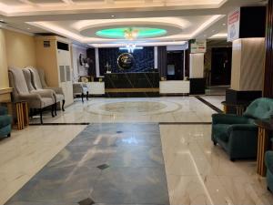 a lobby with a waiting room with chairs and a stage at The Green Shadow Business Hotel in Chittagong